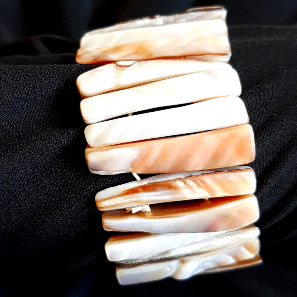 Cuff  Bracelet made of shells.  Mother of Pearl type finish.  Expandable